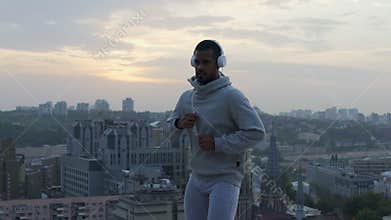 Purposeful hispanic man warming up inspiring with music and beautiful scenery