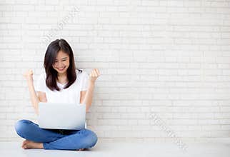 Beautiful of portrait asian young woman excited and glad of success with laptop computer