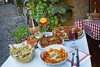 Unidentified people eating traditional italian food in outdoor restaurant in Trastevere district