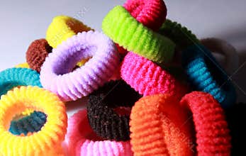 A pile of colorful elastic hair bands with side lighting.