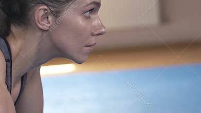 Wet face of a brunette woman after a hard workout. Looking forward. Close-up. Slow motion.