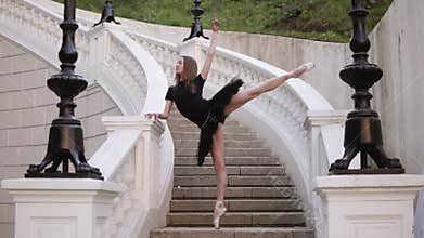 Front view of a graceful ballet movements. Young, blonde haired ballerina doing vertical twine and posing standing on a