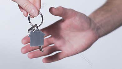 Close-up of hands passing and taking key from house, real estate rental service
