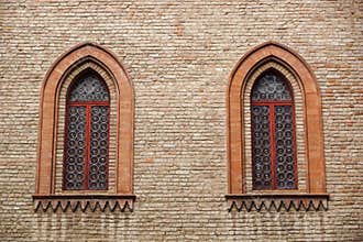 Castle window in a medieval style. Double arched window on a facade of medieval wall. Biforium - ancient window with