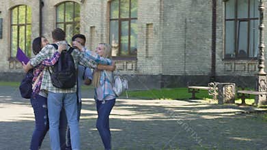 Student walking to best friends waiting him near university, students hugging