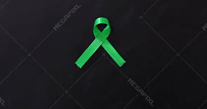 Green awareness ribbon on the chalkboard