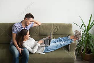 Happy couple lying and watching video together