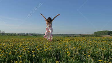 Smiling Happy Woman Walking On A Blooming Yellow Field In A Dress Turning Around