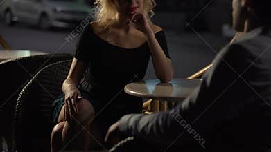 Evening date. Beautiful female sitting in cafe and seducing man, passion