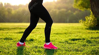 Young muscular fitness woman doing squats exercise in the nature.