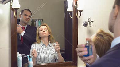 Couple, husband and wife gather in the bathroom in front of the mirror. to be perfumed with perfume. 4k, slow motion