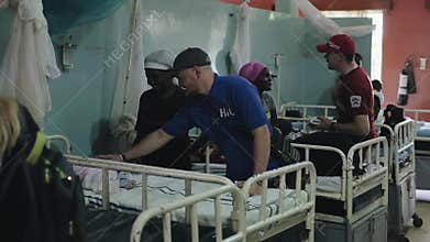 KENYA, KISUMU - MAY 20, 2017: Caucasian men in African hospital talking with people. Volunteers helping to local people.