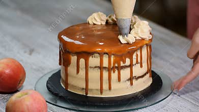 Close-up of woman decorating cake. Making Caramel Apple Cake
