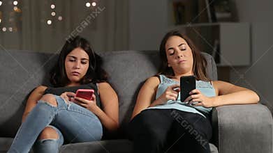 Bored friends ignoring each other using their phones
