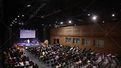 Rear view of the audience at the business conference. Big screen.