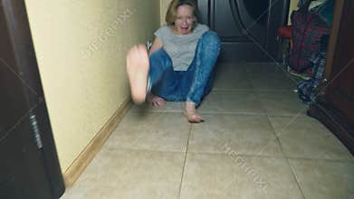 Horror, a girl crawls away from her investigator, falling to the floor in the corridor of her house.