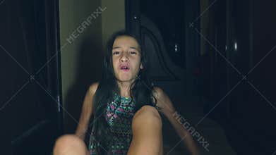 Horror, a girl crawls away from her investigator, falling to the floor in the corridor of her house.