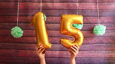 Happy fifteen birthday, golden air balloons with number 15, anniversary celebration with decorations