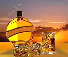 Magic sunset, sunrise in bottle & glass of wiskey.