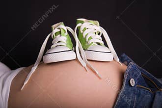 Baby shoes on pregnant belly
