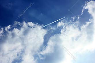 Cloudy blue sky jet trail