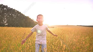 Beautiful asian happy kid run in grass on stunning yellow landscape