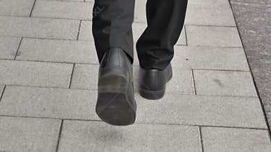 Back view of Walking Feet of Businessman in Suit