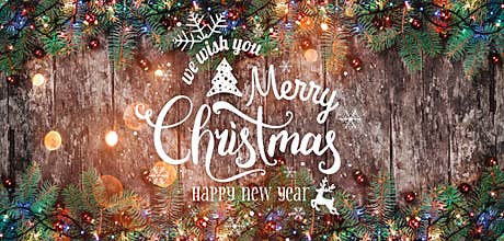 Christmas and New Year Typographical on wooden background with Fir branches.