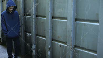 Homeless boy wandering in cold dark backstreet, lost in life, awkward age