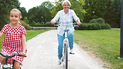 Grandmother and granddaughter cycling at park