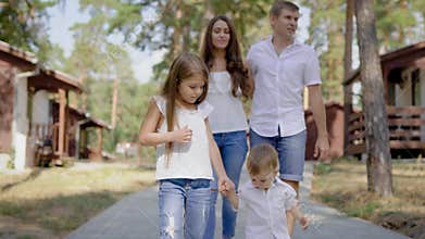 Happy male and female walking with children outside