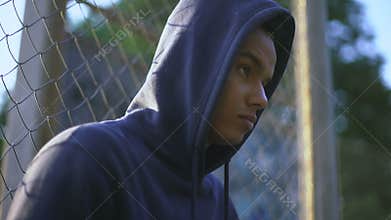 Afro-american teenager holding baseball bat, youth gang in ghetto, closeup