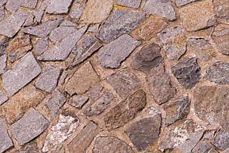 Beige uneven asymmetric stones lime cemented part of the natural wall of the old castle gorada base design