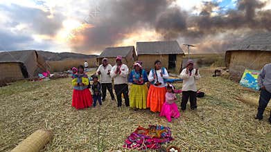 Natives of Titicaca lake dancing and singing in traditional dresses on Uros floating islands in Puno, Peru