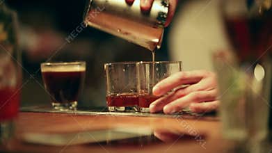 Bartender working. A glass filled with ice. Throwing out the ice from the glasses and pouring the cocktail