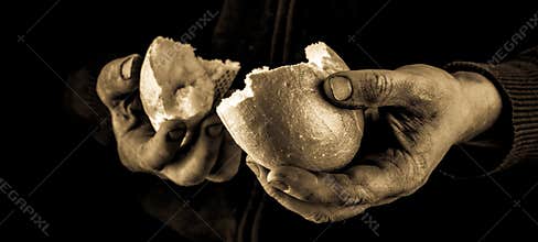 Helping hand giving a piece of bread. Poor Man dividing and sharing Bread, Helping Hand Concept.