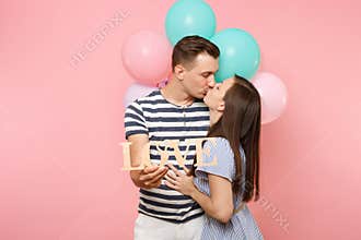 Portrait of young happy kissing couple in love. Woman lean on one`s man chest celebrating birthday holiday party on