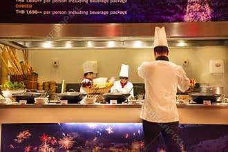 Chef and assistant Chefs cooking and prepared buffet food at restaurant in night time in Bangkok, Thailand