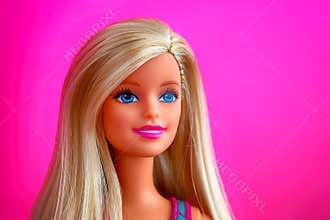Portrait of blond Barbie doll against pink background