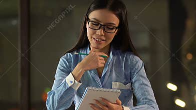 Inspired lady writing action plan for next working day, preparing wish list