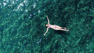 Aerial panorama on woman relaxing on clear sea water