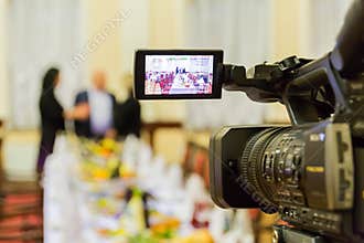 Video shooting at a restaurant at a Banquet. Camcorder with LCD display. People in the hall