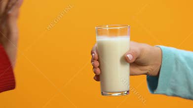 Lady refusing glass of milk offered by person, allergy and lactose intolerance