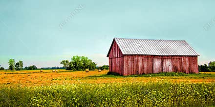 Old red barn in a field with aqua blue sky
