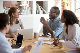 African male employee speaking sharing ideas at diverse team meeting