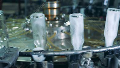 Washing equipment works at a factory, spraying bottles.