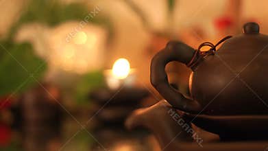 Chinese tea pot on burning candles background. Tea kettle for traditional chinese ceremony. Asian culture and tradition.
