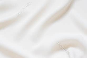 Matte cream soft pleated fabric background. Smooth elegant luxury cloth texture. Gentle pastel color wedding background
