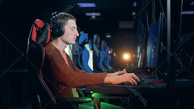 Side view of a man playing a videogame in a club