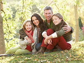 Family Relaxing Outdoors In Autumn Landscape